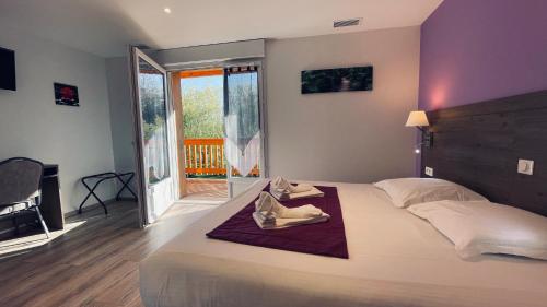 a bedroom with a bed with a pair of shoes on it at Auberge de la Petite Reine in Siorac-en-Périgord