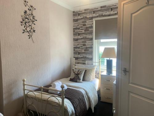 a bedroom with a bed and a brick wall at Arran Lodge B&B in Torquay
