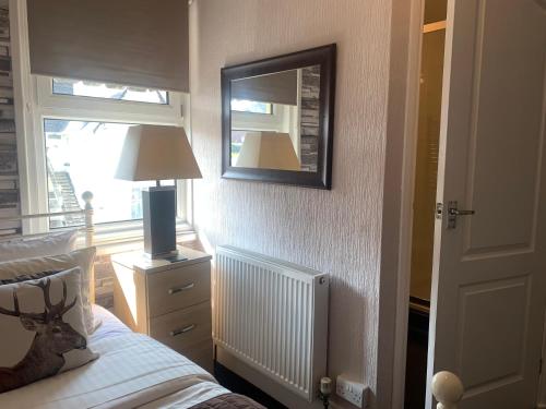 a bedroom with a bed and a mirror and a window at Arran Lodge B&B in Torquay