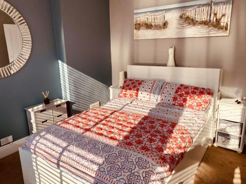 ein Schlafzimmer mit einem Bett mit einer Decke darauf in der Unterkunft Alexandra Beach Haven in Worthing