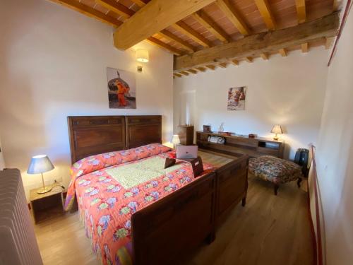 a bedroom with a bed and a desk with a laptop at Campora House in Tavarnelle Val di Pesa