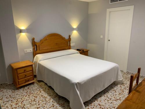 ein Schlafzimmer mit einem weißen Bett und zwei Nachttischen in der Unterkunft Hotel Estrella Del Mar in Motril