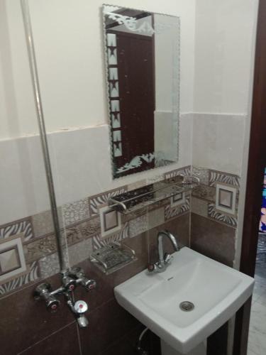 a bathroom with a sink and a mirror at New Taj Hotel in Lahore