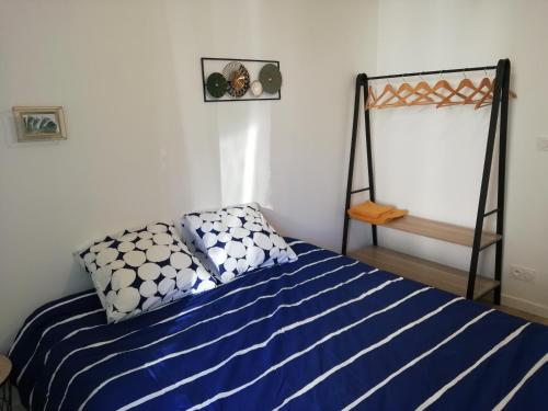 een slaapkamer met een bed met blauwe en witte lakens bij Au Rythme de Concarneau in Concarneau