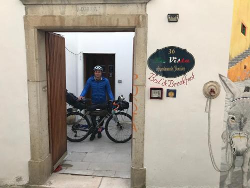 a man standing in a doorway with a bike at La Vista in Calitri