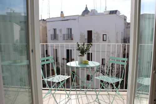 una mesa y sillas en un balcón con vistas a un edificio en Santa Maria 24, en Monopoli