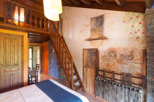 a bedroom with a staircase and a painting on the wall at Hotel Costa de Rodiles in Selorio