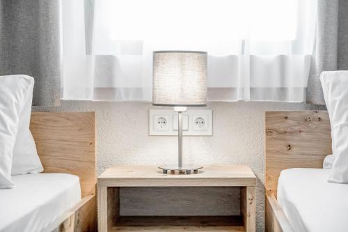 a lamp on a table between two beds at Gasthof Schroll in Kirchbichl