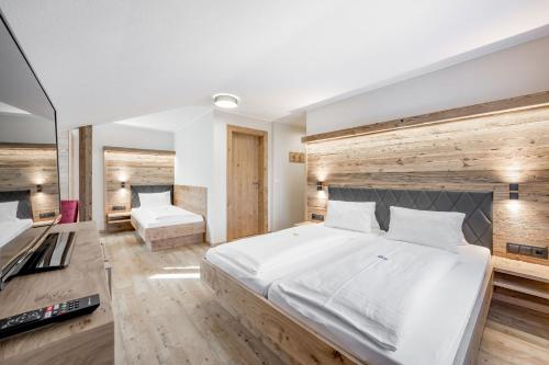 a bedroom with a large bed with a wooden wall at Gasthof Schroll in Kirchbichl