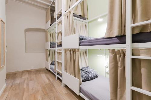 a group of bunk beds in a room with wood floors at Backpackers in Antibes