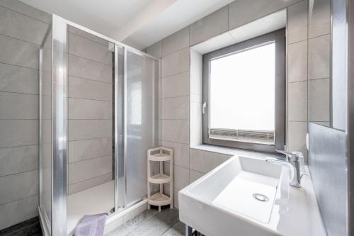 a white bathroom with a sink and a window at Gasthof Schroll in Kirchbichl