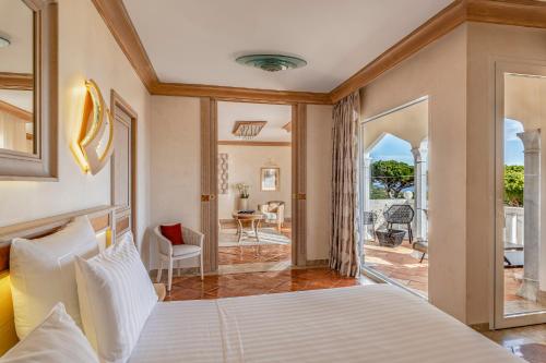 a bedroom with a bed and a living room at Airelles Château de la Messardière in Saint-Tropez