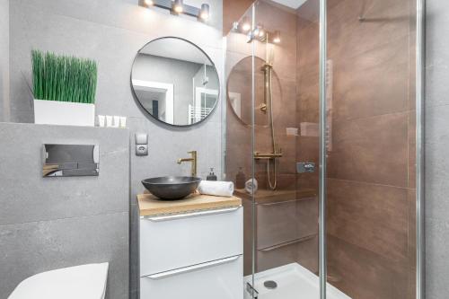 a bathroom with a sink and a mirror at Apartamenty Wyspa Solna by Renters in Kołobrzeg