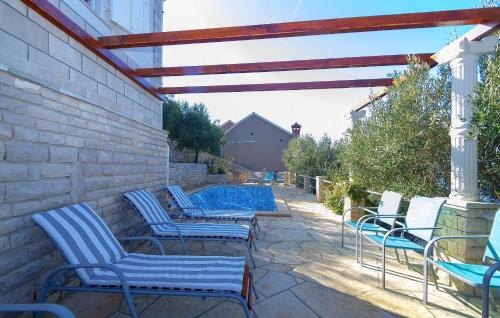 a group of chairs on a patio with a pool at House Green Side Sunset in Prigradica