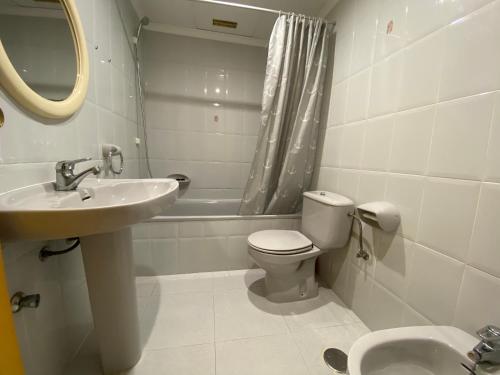 y baño con lavabo, aseo y espejo. en Apartamentos Irta Playa Altamar, en Alcossebre