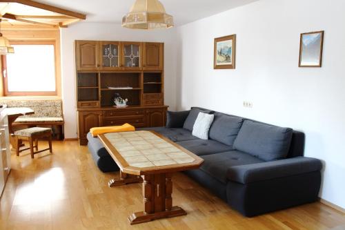 a living room with a blue couch and a table at Ferienwohnung Innerhofer in Hollersbach im Pinzgau