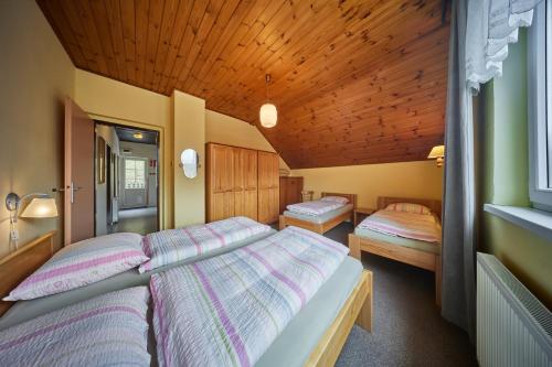 um quarto com 2 camas e um tecto de madeira em Apartmán Svoboda em Svoboda nad Úpou