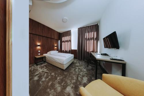 a hotel room with a bed and a desk at Hotel Sliško in Zagreb