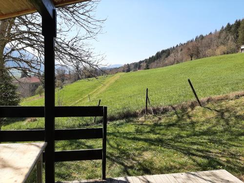 a view of a green field with a fence at chalet du camping la Porte St Martin in Saint-Martin-en-Vercors