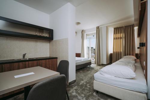 a hotel room with a bed and a desk and a sink at Hotel Sliško in Zagreb
