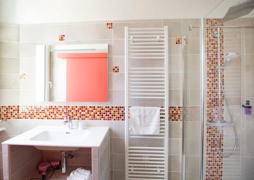 a bathroom with a sink and a shower at Logis Hotel & Restaurant Le Carnot in Die