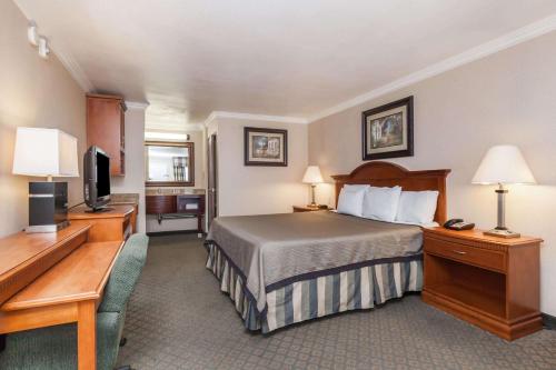 une chambre d'hôtel avec un lit et une télévision dans l'établissement Travelodge by Wyndham Sylmar CA, à Sylmar