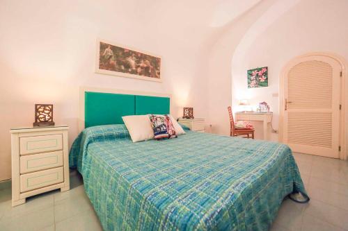 a bedroom with a bed with a green comforter at Atrani Apartments on the Amalfi Coast, air-purified, close to the beach and easy access in Atrani