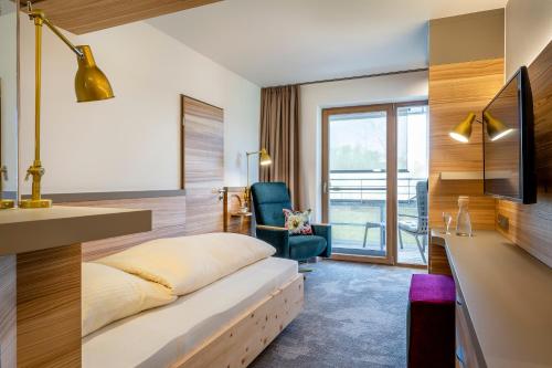 a hotel room with a bed and a desk at Hotel FrechDachs in Bad Füssing