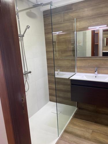 a bathroom with a glass shower and a sink at Alojamento das Caldas in Caldas de Aregos