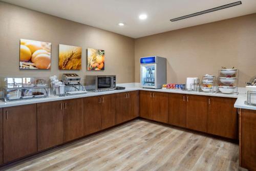 a large kitchen with wooden cabinets and a refrigerator at Comfort Inn & Suites in Harrisonburg