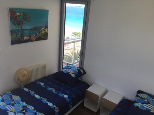 sypialnia z łóżkiem i balkonem z widokiem na ocean w obiekcie Bord de mer - Cannes la Bocca w Cannes