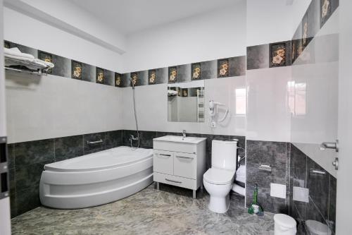 uma casa de banho com um WC, uma banheira e um lavatório. em Hotel Ema&Zain em Bucareste