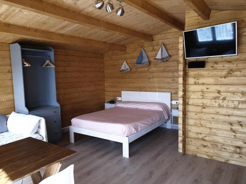 a bedroom with a bed and a flat screen tv at RinloCosta Camping in Rinlo