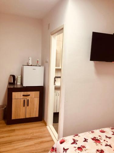 a bedroom with a door leading to a kitchen at Prenoćište Vojkić in Sombor