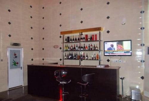 a bar with two stools and a shelf of alcohol at Dublina Hotels - Superior in Asaba