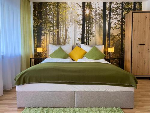 a bedroom with a large bed with green and yellow pillows at Wanderlust Apartment Baden-Baden in Baden-Baden