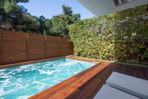 a swimming pool in a garden with a fence at Elegant and Private Living by Neuvel in Athens