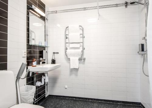 a white bathroom with a sink and a mirror at Wij Trädgårdar in Ockelbo