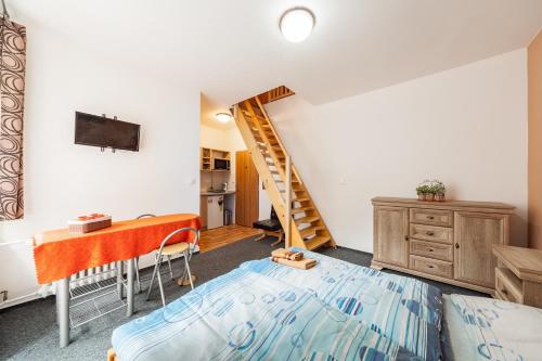 a bedroom with a bed and a desk and a staircase at Penzion U Hráze in Luhačovice