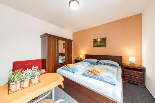 a bedroom with a bed and a wooden table at Penzion U Hráze in Luhačovice
