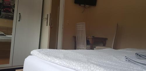 a bedroom with a white bed and a table at Zum Fuchsbau in Niederhövels