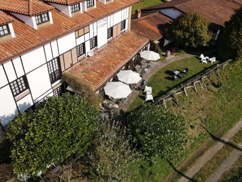 an aerial view of a building with tables and umbrellas at Hotel Colegiata in Santillana del Mar