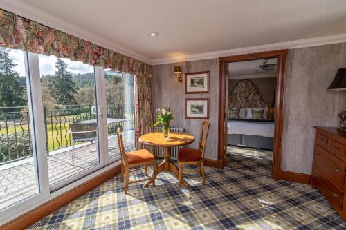 a room with a table and chairs and a bedroom at Dunkeld House Hotel in Dunkeld