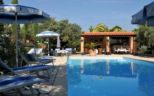 une piscine avec des chaises et un parasol ainsi qu'une maison dans l'établissement Residence 