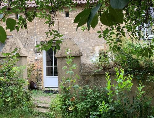 ÉcommoyにあるMaison de vacancesの白い扉のある古い石造りの家