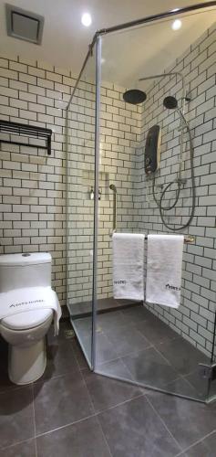 a bathroom with a toilet and a shower with towels at VISTA HOTEL in Tawau