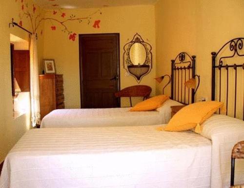 1 dormitorio con 2 camas y espejo en la pared en Baraka Pensión en Ronda