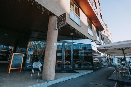 a store front with tables and chairs and a sign at Hotel Sliško in Zagreb