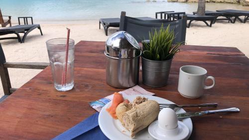 a table with a plate of food on the beach at Advantage Apartments Curacao in Willemstad