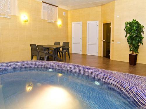 una piscina en una habitación con mesa y sillas en Villa Diego, en Rostov-on-Don